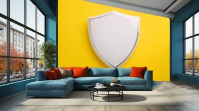 White shield against yellow background. Minimalist design. Security and protection concept. Wall mural