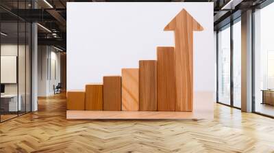 Wooden rising bar graph with an upward arrow on white background. Growth or progress. Wall mural