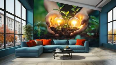 A person is holding two light bulbs in their hands, one of which is glowing Wall mural