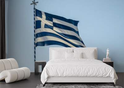 Greek flag waving on a blue and white pole with a cross at the top Wall mural