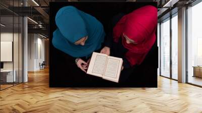 Two Muslim girls reading a holy book Quran inside the mosque. Wall mural