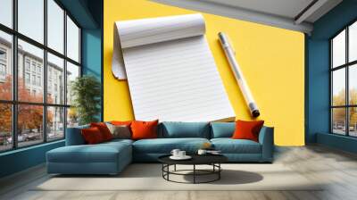 Top view of blank open notebook page with lines and transparent minimalistic fineliner pen on yellow background with copy space. For use as mock up.     Wall mural