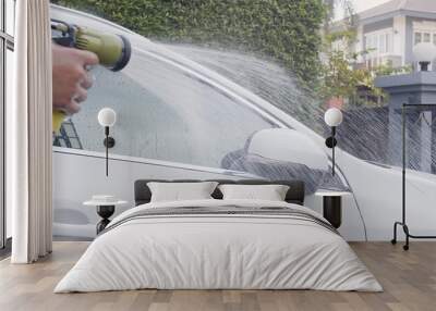 Asian man spray clean water to wash clean dirt foam on white car at home	
 Wall mural