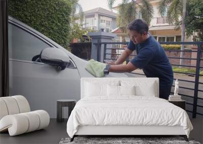 Asian man washing clean dirt with soap water foam on white car at home	 Wall mural