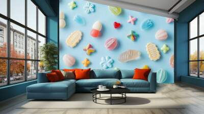 A flat lay of Easter candies in various shapes on a pale blue background Wall mural