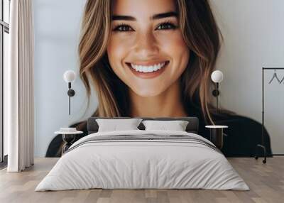 A smiling woman holding a laptop, isolated on a white background, conveying a sense of approachability and modernity. Wall mural