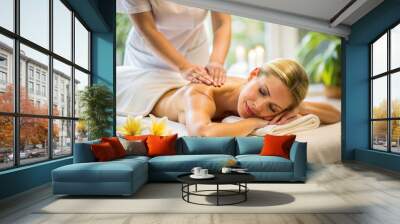 young beautiful woman enjoying massage in spa and wellness concept Wall mural