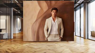 The male model, with a debonair demeanor, straightens his jacket while standing against a luxurious cream wall, exuding confidence and refinement. Wall mural