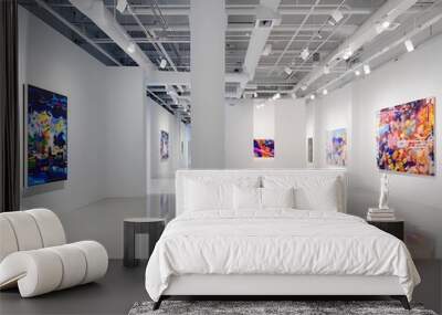 A sleek art gallery with white walls and high ceilings, displaying a curated selection of contemporary paintings that create a powerful visual statement. Wall mural