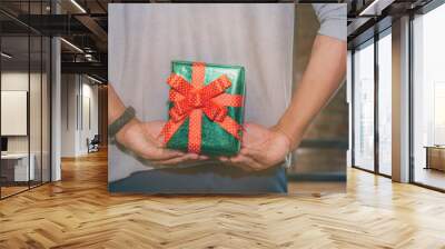 Man standing and holding valentine's gift box behind his back for surprise his lovely girlfriend. Wall mural