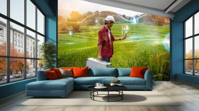 Agricultural engineering innovation modern technology Asian man farmer using mobile smartphone using application detect searching area for water level and plant health, rice field mountain background Wall mural