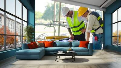 Contractor and engineer architect working together planning using blueprint design structure construction industry, building house innovation and teamwork discussing, two male caucasian collaborating. Wall mural