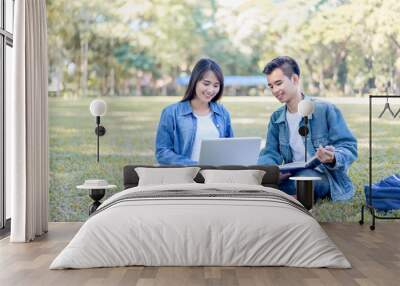 Education study abroad, group of Asian student boy with book and girl sitting at the park talking look at laptop  using internet friend connection, businesswoman use computer analysis finance data Wall mural