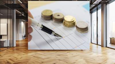 Finances statement with Pen,hand pointing pen on financial charts, paper work in the office,Finance Business,discussing on stock market charts pens pointing at business document during discussion Wall mural