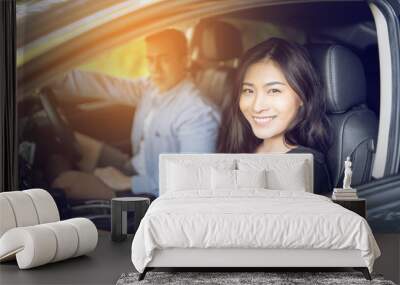 woman and man Enjoying to travel. Asian couple sitting on the front passenger seats ,they smiling while  driving a car  on the road Wall mural