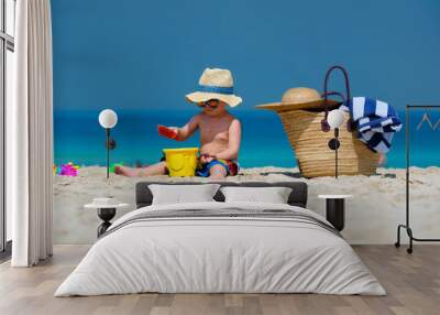 Two year old toddler boy playing with beach toys on beach Wall mural