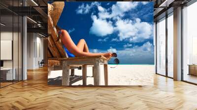 Woman at beach holding sunglasses Wall mural