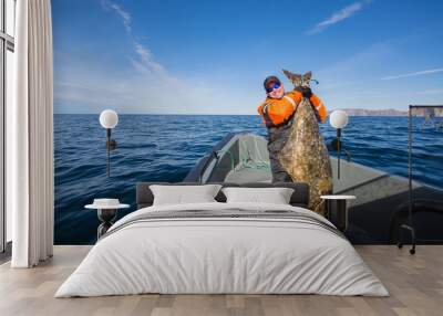 fisherman in the middle of the sea with a huge fish Wall mural