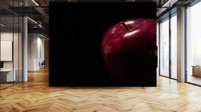 Closeup of a dark red shiny apple on a black background Wall mural