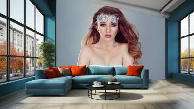 Sexy and beautiful. Beauty Queen bride woman with bright blue crystals jewelry on head looking at you camera purple bridal makeup isolated light gray white background wall Wall mural