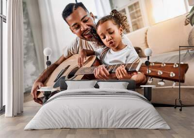  Dad teaches daughter to play guitar in living room. A little african american girl is singing. Dad and daughter spend time together. Wall mural