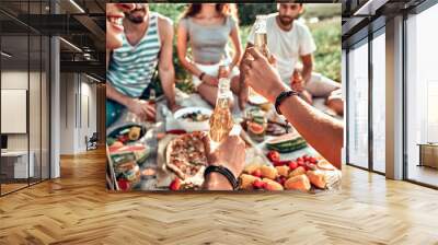 Happy young friends having picnic in the park. Wall mural