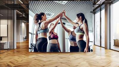 Sporty fit women wearing sportswear giving five each other after having a great fitness class Wall mural