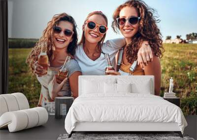 Three friends in camp while celebrating by drinking a beer in a moment of relaxation Wall mural