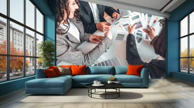 Top view cropped image of young couple looking at catalog color examples for building decoration. Professional designer helps to choose color on swatches to sucessful family. Design studio concept Wall mural