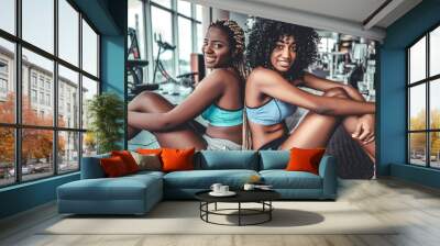 Two young friends resting after long workout at gym Wall mural