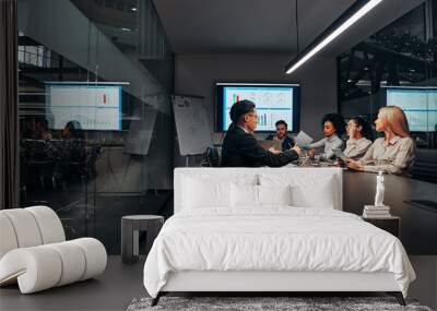 Work team. A group of successful business people work hard in the conference room of a large spacious office. In the room there is a monitor with graphs and a flipchart with a plan. Wall mural