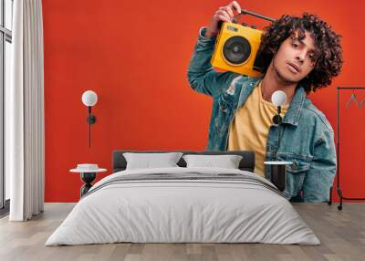 Young man with vintage beat box on isolated red background Wall mural