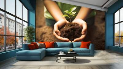 Hand holding a small plant with soil. Concept of caring for the environment. AI generated image Wall mural