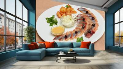 Pieces of herring with potatoes and greens on plate Wall mural