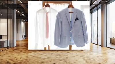 White shirt and gray suit of groom hanging on hanger Wall mural