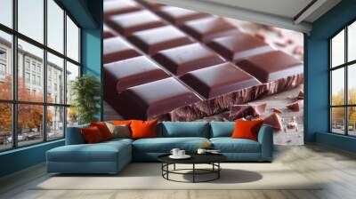 Close-up of a delicious dark chocolate bar with a bite taken out, surrounded by scattered chocolate pieces on a wooden surface. Wall mural