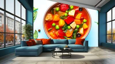 Vibrant vegetable soup in a bowl surrounded by fresh ingredients, including peppers, herbs, and lemon, on a light blue background, perfect for healthy cooking visuals. Wall mural