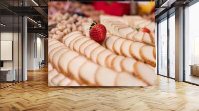 A strawberry on top of slices of cheese.  cheese with fruit on the aperitif table. Food, appetizers on a fourchette table, cheese, strawberries, nuts. raclette cheese meal tasty. Wall mural