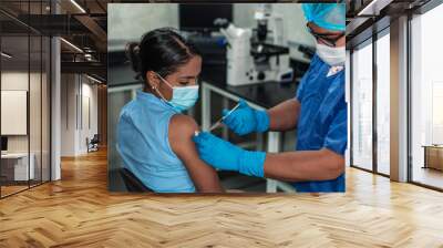 Hispanic woman receiving coronavirus vaccine Wall mural