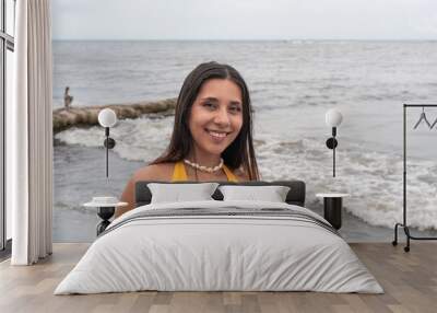 Smiling Woman Posing by the Ocean Shoreline Wall mural