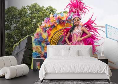 Woman in a vibrant pink costume performing on a parade float at a festival Wall mural