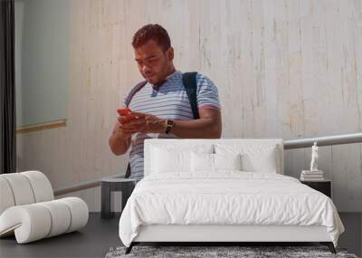 Young Man Checking His Phone Outside Wall mural