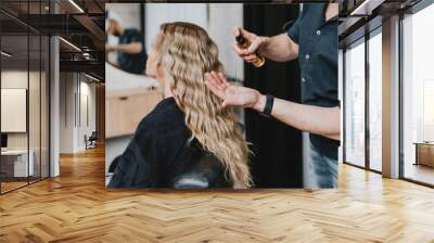 Beautiful blonde wavy hair of a young woman after a treatment in a hair salon. Wall mural