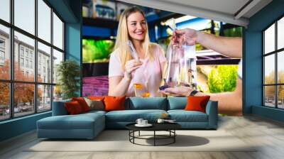 Beautiful young woman buying fishes in a fish shop. Wall mural