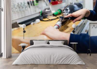 Disabled man working in amputee shop for production prosthetic extremity parts. Wall mural