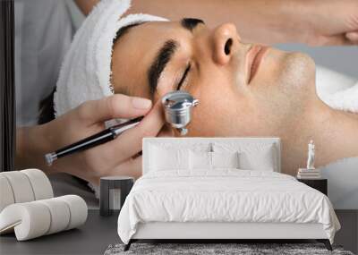 Facial beauty treatment of good looking man with oxygen epidermal peeling at cosmetic beauty salon. Wall mural