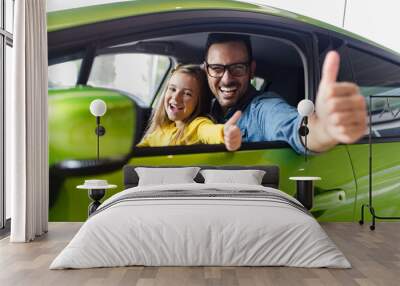 Father and daughter buying a new car at the car showroom. Wall mural