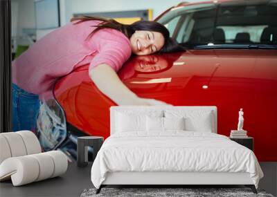 Happy beautiful young woman buying a new car at the car showroom. Wall mural