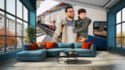 Happy family, father and his son, are waiting for train in subway. Wall mural