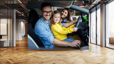 Happy family buying a new car at the car showroom. Wall mural